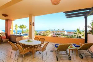 patio ze stołem i krzesłami oraz oceanem w obiekcie Malibu Mansions with private hot tub w mieście Mijas Costa