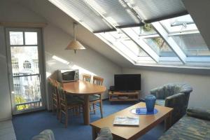 a living room with a skylight and a table and a television at Villa Granitz - Ferienwohnung Riedel in Göhren