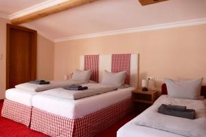 a room with two beds with white pillows at Pension DORFPLATZL Pitztal in Plangeross
