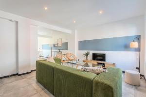 a living room with a green couch and a table at House 4bed 2bath with garden and private parking. in La Madeleine