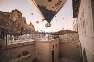 un globo de aire caliente volando en el cielo sobre un edificio en DAPHNE CAVE HOTEL, en Avanos