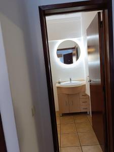 ein Bad mit einem Waschbecken und einem Spiegel in der Unterkunft Jardim de Mar in Carvoeiro
