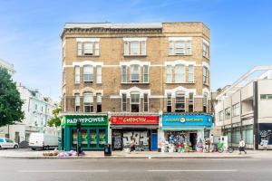 a building on the corner of a street with shops at Chic Top Floor Apartment in the heart of Notting Hill Ladbroke Grove in London