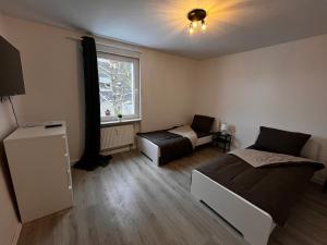 1 dormitorio con 2 camas y ventana en Tolle Monteursunterkunft für 6 Personen en Ennepetal