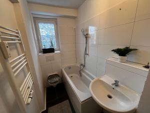 La salle de bains est pourvue d'un lavabo, de toilettes et d'une baignoire. dans l'établissement Tolle Monteursunterkunft für 6 Personen, à Ennepetal
