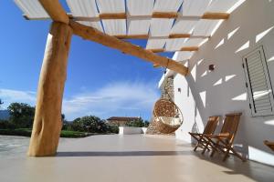 a view of a patio with two chairs and a building at Amoreddu in San Teodoro