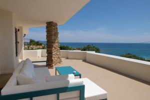 a balcony with white furniture and a view of the ocean at Amoreddu in San Teodoro