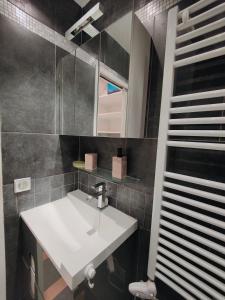 een badkamer met een witte wastafel en een spiegel bij Stunning loft - sunny terrace - Paris in Parijs
