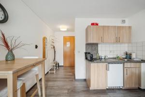cocina con armarios de madera y encimera en Salí Homes HS3 Studio Bahnhof Nähe mit Terrasse, en Bayreuth