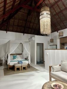a bedroom with a bed and a couch and a chandelier at Yapak Beach Villas in San Isidro