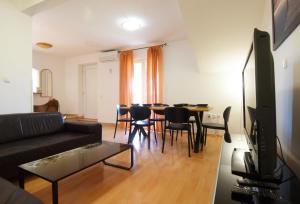 a living room with a couch and a table and chairs at Suitable Summer Apartments in Pula
