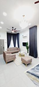 a living room with two couches and a ceiling fan at Family Homstay kulim Hitech in Kampong Sira