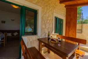a wooden table with two glasses of wine on a house at Marva Cliff Apartments in Zubovići