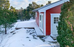une maison rouge avec une porte blanche dans la neige dans l'établissement Amazing Home In Mariefred With Kitchen, à Mariefred