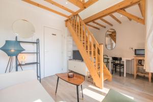 ein Wohnzimmer mit einer Wendeltreppe und einem Tisch in der Unterkunft Emplacement central pour ce studio Vieux Lille in Lille