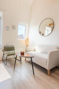 uma sala de estar com um sofá branco e uma mesa em Emplacement central pour ce studio Vieux Lille em Lille