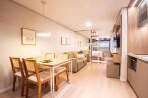 a kitchen and a living room with a table and chairs at Studio 313 Parque Una in Pelotas