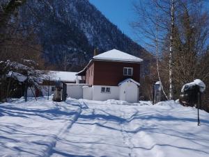 una casa en la nieve con una montaña en el fondo en L'impératrice, en Eaux-Bonnes