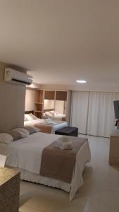 um quarto de hotel com duas camas e uma televisão em Tabatinga Residence Service - Flat 02 em Conde