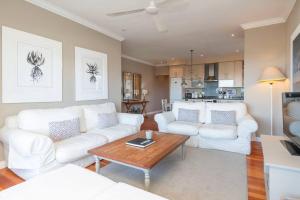 una sala de estar con 2 sofás blancos y una mesa. en 2 Bedroom Apartment With Amazing City Views, en Ciudad del Cabo