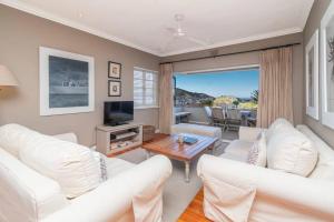 sala de estar con sofás blancos y TV en 2 Bedroom Apartment With Amazing City Views, en Ciudad del Cabo