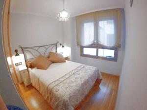 een slaapkamer met een groot bed en een raam bij Sunshine beach Gijón in Gijón