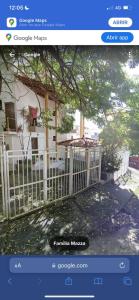 a picture of a white fence in front of a house at Apartamento temporada carnaval in Salvador