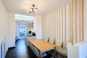 a dining room with a table and a couch at Renovated 3 bedroom house with terrace in Tourcoing