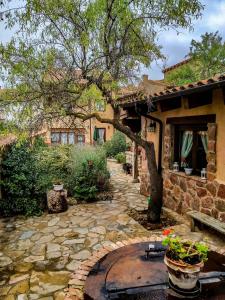 a stone walkway in front of a house with a tree at Casa Rural Islas Galápagos in Berlanga de Duero