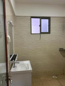baño con lavabo y ventana en mopearlz skyhorse apartment, en Nairobi