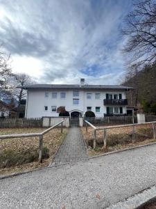 a white house with a fence in front of it at Mini Loft Apartment in Garmisch-Partenkirchen