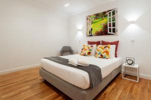 a bedroom with a bed with a painting on the wall at Apartamento Premium Douro River Views in Porto