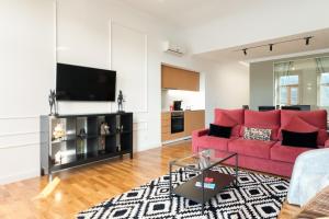 a living room with a red couch and a flat screen tv at Apartamento Premium Douro River Views in Porto