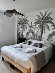 - une chambre avec un grand lit recouvert de palmiers dans l'établissement Le Loly, à Clermont-Ferrand
