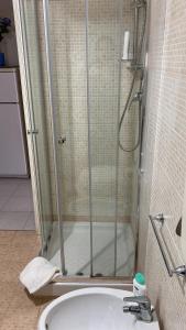um chuveiro com uma porta de vidro ao lado de uma banheira em Busalacchi B&B em Mondello