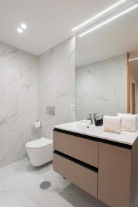 a white bathroom with a sink and a toilet at Apartamento Premium Douro River Views in Porto