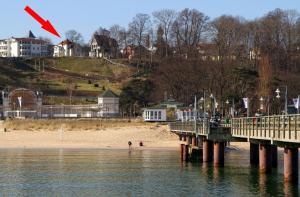 a kite flying over a beach and a pier at Strandvilla Rheingold in Göhren