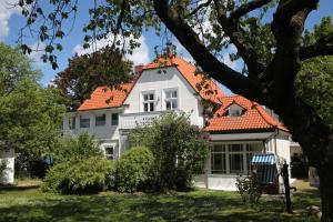 a white house with an orange roof at Strandvilla Rheingold in Göhren