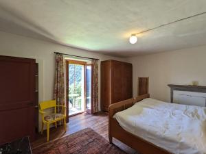 1 dormitorio con 1 cama y puerta corredera de cristal en Wild Valley Garden Paradise in Valle Onsernone, en Auressio