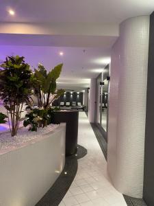 a lobby of a hotel with potted plants at Hanza Tower Apartament Times Square in Szczecin
