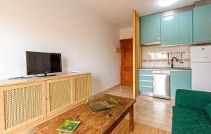a living room with a tv and a kitchen with a table at Lovely Apartment In Puerto De Mazarrón in Puerto de Mazarrón +6 photos