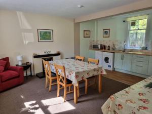 a kitchen and dining room with a table and chairs at The Coach House - Bargany in Girvan
