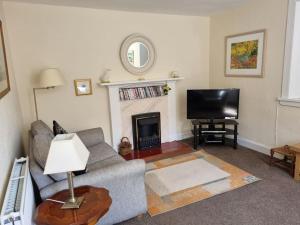 a living room with a couch and a fireplace at The Coach House - Bargany in Girvan