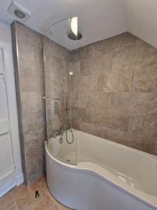 a bathroom with a bath tub and a shower at The Coach House - Bargany in Girvan