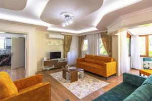 - un salon avec deux canapés et une télévision dans l'établissement Villa Şans, à Fethiye