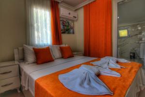 - une chambre avec un lit et des serviettes dans l'établissement Villa Şans, à Fethiye