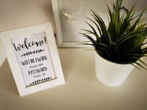 a plant sitting next to a sign next to a vase at Pintes 38 A in Dunaújváros