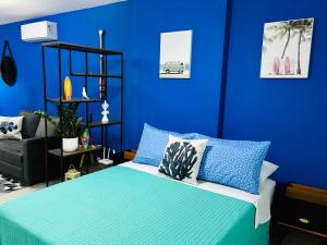 ein blaues Schlafzimmer mit einem Bett mit blauen Wänden in der Unterkunft Studio Acqua - estilo no melhor bairro da cidade in Niterói