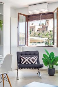 a black couch in a room with a window at Apartamentos Bravo by A3 Rentals in Granada