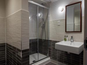 a bathroom with a shower and a sink and a mirror at The Carpenters Arms in Tonbridge